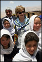 Mrs. Laura Bush is joined by Ihsan Ullah Bayat, top let, and young Afghan girls during a tour of the construction site of the Ayenda Learning Center Sunday, June 8, 2008, in Bamiyan, Afghanistan. White House photo by Shealah Craighead