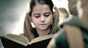 A young girl reading a book.