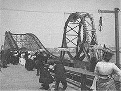 Photo: People looking at a woodeen roller coaster  with a loop.