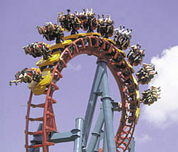 Photo:  Newer style steel roller coaster,  in which the riders dangling out beyond the track.