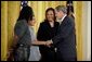 Talking with Dante Nelms, 12, President George W. Bush greets Dante's mother, Pamela Hedrick, right, her husband, Martia Jackson, and her son Darius McIver, 5,(not pictured) during a program honoring graduates of welfare-to-work programs in the East Room Tuesday, Jan. 14, 2003. Ms. Hedrick was on public assistance for eight years in Columbus, Ohio, before volunteering at the Greenbriar Enrichment Center, where she organized a women's support group and received job training. White House photo by Paul Morse.