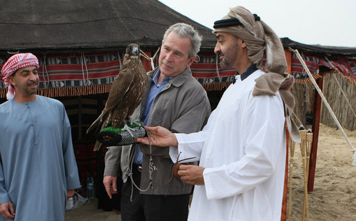 President George W. Bush holds a falcon as the Crown Prince of Abu Dhabi, Sheikh Mohammed bin Zayed Al Nayhan, stands by during dinner Sunday night, Jan. 13, 2008 in the desert near Abu Dhabi. White House photo by Eric Draper