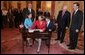 Vice President Dick Cheney and Undersecretary of State Nicholas Burns watch as Toria Nuland signs two Appointment Affidavits Wednesday, July 13, 2005, following her swearing-in as the Ambassador of the United States of America to the North Atlantic Treaty Organization during a ceremony at the U.S. State Department. Mrs. Nuland's family is pictured standing next to her. White House photo by David Bohrer