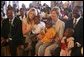 Laura Bush and daughter Jenna sit with children as they visit the Kagarama Church, Thursday, July 14, 2005, in Kigali, Rwanda. White House photo by Krisanne Johnson