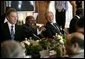 President George W. Bush shares a light moment with Tanzanian President Benjamin Mkapa during the morning session of the G8 Summit Friday, July 8, 2005, at Gleneagles Hotel in Auchterarder, Scotland. Britain's Prime Minister Tony Blair, who returned from London late last night, sits at left. White House photo by Eric Draper