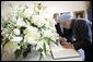 India's Prime Minister Dr. Manmohan Singh is accompanied by U.S. Department of State Chief of Protocal Ambassador Donald Ensenat, Monday, July 18, 2005, as Singh signs the guest book upon his arrival to the White House. White House photo by Eric Draper