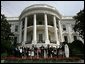 President Bush addresses an audience on the South Lawn, Tuesday, July 12, 2005, standing with the team representatives of the 2004 and 2005 NCAA Sport Championship teams being honored at the White House. White House photo by Eric Draper