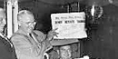 Image of Harry Truman on his train holding up paper denoting his erroneous loss in 1948