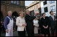 Standing with German Chancellor Angela Merkel, President George W. Bush holds up a ceremonial gift of a barrel of herring in Stralsund, Germany, Thursday, July 13, 2006. Mrs. Bush is pictured at the right. White House photo by Eric Draper