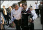 President George W. Bush puts his arm around an accordian player Thursday, July 13, 2006, after an evening barbeque in Trinwillershagen, Germany, hosted by Chancellor Angela Merkel. White House photo by Eric Draper