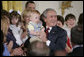 President George W. Bush holds 14-month-old Trey Jones of Cypress, Texas, following his remarks about stem cell research policy legislation in the East Room of the White House Wednesday, July 19, 2006. "Each of these children was adopted while still an embryo, and has been blessed with the chance to grow up in a loving family," said the President of children sharing the stage with him. "These boys and girls are not spare parts. They remind us of what is lost when embryos are destroyed in the name of research." Trey Jones was first introduced to the President during a White House visit in May 2005. White House photo by Kimberlee Hewitt