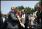 President George W. Bush and Iraqi Prime Minister Nouri al-Maliki pose for a photo with five-year-old Isabelle Colletti during their visit Wednesday, July 26, 2006 to Fort Belvoir, Va., where they met with military personnel and their families. White House photo by Paul Morse