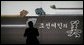 A spectator is silhouetted as he takes a photo from a doorway at the Busan Museum in Busan, Korea, where Laura Bush was visiting Saturday morning. White House photo by Shealah Craighead