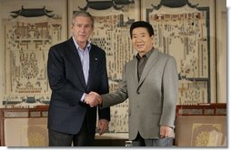 President George W. Bush and Korea President Moo Hyun Roh exchange handshakes Thursday, Nov. 17, 2005, after their meeting at the Hotel Hyundai in Gyeongju, Korea.  White House photo by Eric Draper