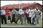 Under the watchful eyes of New York Yankee's Mariano Rivera, second from left, and Panama President Martin Torrijos, third from left, President George W. Bush releases a pitch Monday, Nov. 7, 2005, during a visit with Panamanian youth at Ciudad Del Saber in Panama City, Panama. White House photo by Paul Morse