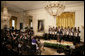 President George W. Bush, standing with members of the Jackson High School Black History Tour Group of Jackson, Mich., welcomes guests to the East Room of the White House, Monday, Feb. 12, 2007, during the celebration of African American History Month. White House photo by Eric Draper