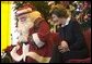 Laura Bush talks with children from New Orleans neighborhoods as she sits with Santa Claus, Monday Dec. 12, 2005 at the Celebration Church in Metairie, La., during a Toys for Tots event. White House photo by Shealah Craighead