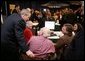 President Bush leans over to view a computer screen as he visits with participants Tuesday, Dec. 13, 2005, at the Medicare Prescription Drug Educational and Enrollment Event at the Greenspring Village Retirement Community in Springfield, Va. White House photo by Paul Morse