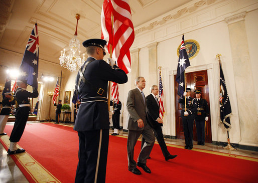 President George W. Bush and Australian Prime Minister pass an honor guard as the walk together through the Cross Hall Friday, March 28, 2008, after a joint press availability in the East Room of the White House. White House photo by Eric Draper