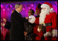 President George W. Bush exchanges knuckles with Santa Thursday, Dec. 4, 2008, during the 2008 Lighting of the National Christmas Tree Ceremony on the Ellipse in Washington, D.C. It is the 85th year of the ceremony that began during the Coolidge Administration. White House photo by Eric Draper