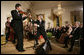 President George W. Bush watches as Japanese Prime Minister Junichiro Koizumi adjusts the microphone for country music entertainer Shoji Tabuchi Thursday evening, June 29, 2006 in the East Room of the White House, during the entertainment following the official dinner in honor of Koizumi’s visit to the United States. White House photo by Eric Draper