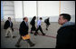 Accompanied by Dan Bartlett, left, Counselor to the President, and Deputy Chief of Staff Joe Hagin, President George W. Bush arrives at Andrews Air Force Base Monday night, June 12, 2006, en route to Iraq. White House photo by Eric Draper