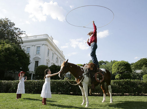 Children attending the annual Congressional Picnic on the South Lawn of the White House Wednesday evening, June 15, 2006, watch a rope trick cowboy entertainer. White House photo by Paul Morse