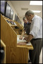 President George W. Bush looks over navigational charts of the Chesapeake Bay with student, Andrew Ashworth, direct left and John Mason, President of Seafareres International Union,far left, during a tour of the Paul Hall Center for Maritime Training and Education on Monday, September 4, 2006. White House photo by Kimberlee Hewitt