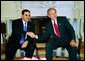 El Presidente George W. Bush se reúne con el Presidente Antonio Saca de El Salvador en la Oficina Oval el Lunes, 12 de julio de 2004. White House photo by Eric Draper