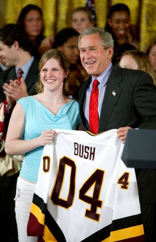 President George W. Bush stands with Kelsey Bills of the University of Minnesota's women's hockey team during a ceremony in the East Room congratulating four NCAA teams for winning national titles Wednesday, May 19, 2004. White House photo by Paul Morse.