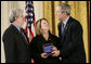 President George W. Bush presents a National Medal of Technology, Monday, Feb. 13, 2006 to George Lucas, left, and Chrissie England, of Industrial Light and Magic of San Francisco, Calif., during ceremonies in the East Room of the White House. White House photo by Eric Draper