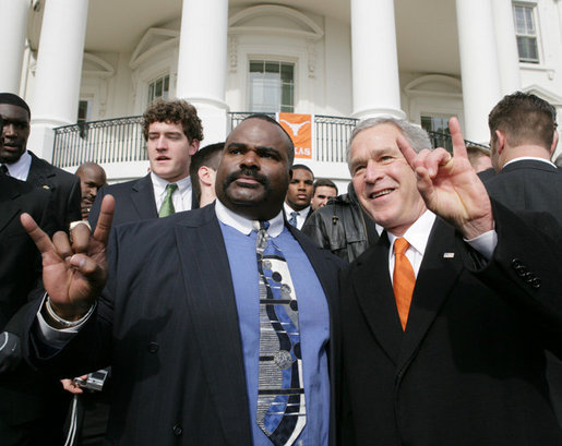 President George W. Bush poses with University of Texas Longhorns assistant coach Jeff 'Mad Dog' Madden, as they give the 'Hook Em Horns' sign, Tuesday, Feb. 14, 2006 on the South Lawn of the White House, during ceremonies to honor the 2005 NCAA Football Champions. White House photo by Paul Morse