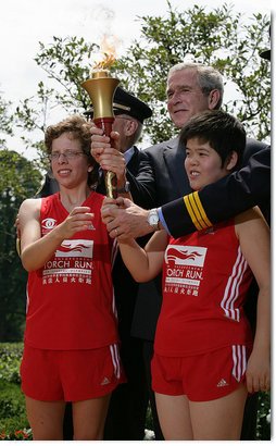 President George W. Bush and Police Chief Russ Laine of Algonquin, Ill., stand with torch runners Karen Dickerson of Springfield, Va., left, and Qiao Meili of Shanghai, China, during a Special Olympics Global Law Enforcement Torch Run Ceremony Thursday, July 26, 2007, in the Rose Garden. White House photo by Eric Draper