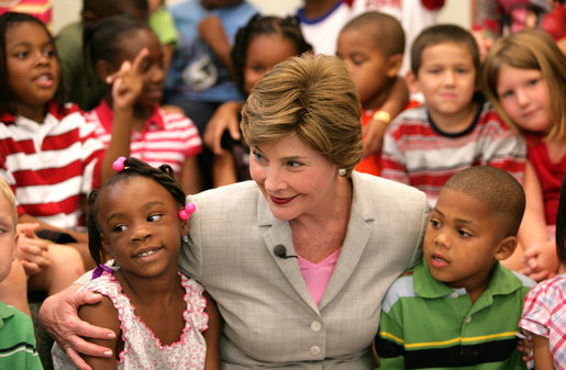 Mrs. Laura Bush embraces two students Monday, Aug. 28, 2006, as she meets and speaks with members of the Gorenflo Elementary School first grade class in their temporary portable classroom at the Beauvoir Elementary School in Biloxi, Miss. The students, whose school was damaged by Hurricane Katrina, are sharing the facilities of the Beauvoir school until their school’s renovations are complete. White House photo by Shealah Craighead