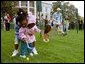 A helping hand is given during the Easter egg roll where little competitors use a spoon to carry a hard-boiled egg through the South Lawn race course and across the finish line at the White House Easter Egg Roll Monday, April 21, 2003. File photo. White House photo by Susan Sterner