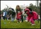 Slipping and sliding, eggs are tossed in rainy race on the South Lawn during the 2004 White House Easter Egg Roll Monday, April 12, 2004. Because of inclement weather, the annual event closed at noon. File photo. White House photo by Paul Morse