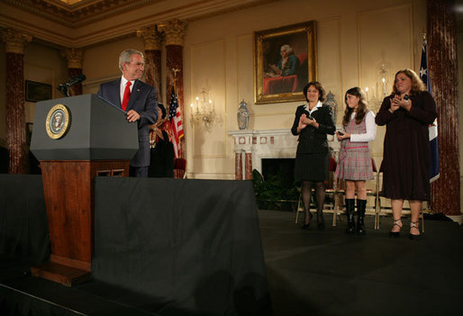 President George W. Bush acknowledges his guests, from left to right, Yamile Llanes Labrada, Melissa Gonzalez, and Marlenis Gonzalez during his remarks on Cuba policy, Wednesday, October 24, 2007, at the State Department in Washington, D.C. Labrada is the wife of Jorge Luis Garcia Paneque, a surgeon and journalist who was sentenced to 24 years in prison for speaking out against the regime. Melissa's father, Jorge Luis Gonzalez Tanquero is currently being held in a Cuban prison after being arrested for crimes against the state. White House photo by Eric Draper