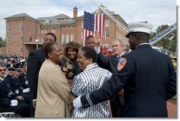 President George Bush shares a light moment with friends and family of a fallen firefighter during a ceremony at the National Fallen Firefighters Memorial in Emmitsburg, Md., Sunday, Oct. 7, 2007. White House photo by Chris Greenberg