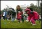 Slipping and sliding, eggs are tossed in rainy race on the South Lawn during the 2004 White House Easter Egg Roll Monday, April 12, 2004. Because of inclement weather, the annual event closed at noon.