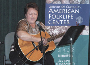 Elaine Purkey singing and playing the guitar