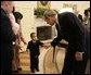 President George W. Bush reaches out for the hand of young Chandra Fincke, son of Lt. Colonel Mike Fincke and wife Renita, as the family joined fellow crewmembers of International Space Station flights for a visit to the Oval Office. White House photo by Eric Draper