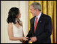 President George W. Bush congratulates Angela An of Washington, D.C., on presenting her the President’s Volunteer Service Award Thursday, May 10, 2007, in the East Room of the White House, in celebration of Asian Pacific American Heritage Month. White House photo by Eric Draper