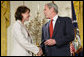 President George W. Bush congratulates military spouse Shannon Maxwell of Jacksonville, N.C., as Maxwell is presented with the President’s Volunteer Service Award Friday, May 11, 2007, in the East Room of the White House during a celebration of Military Spouse Day. White House photo by Eric Draper