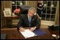 President George W. Bush signs legislation in the Oval Office Friday, Sept. 2, 2005, to provide 10.5 billion dollars in relief aid for the areas along the Gulf Coast affected by Hurricane Katrina. Congress approved the bill late Thursday. White House photo by Paul Morse