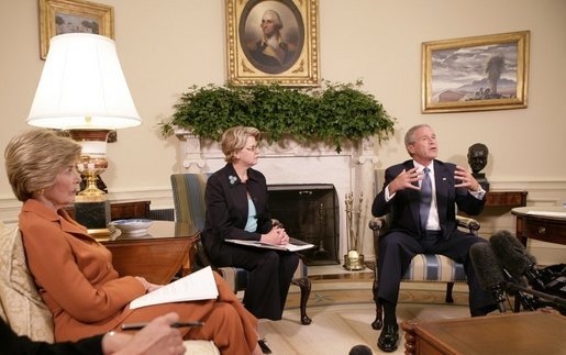 President George W. Bush, seen with U.S. Secretary of Education Margaret Spellings, center, and Laura Bush, left, gestures as he speaks with reporters, Tuesday, Sept. 6, 2005 in the Oval Office at the White House, about efforts the Department of Education is undertaking with a program, "Hurricane Help for Schools," established to assist schools and students affected by Hurricane Katrina. White House photo by Eric Draper