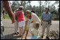 Laura Bush visits with a family outside their hurricane damaged home, Monday, Sept. 5, 2005, on West Ida Street in Poplarville, Miss. President George W. Bush and Mrs. Bush made the visit during their trip through the hurricane ravaged areas of the Gulf Coast. White House photo by Krisanne Johnson