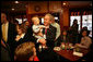 President George W. Bush gets up close and personal with a child as he arrived Friday, Feb. 1, 2008, at Eggtc., a home-style restaurant in Kansas City, where he met local business leaders over breakfast. White House photo by Eric Draper