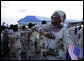 A woman waves a U.S. flag as Air Force One arrives at Julius Nyerere International Airport Saturday in Dar es Salaam. The arrival of President George W. Bush and Mrs. Laura Bush brought thousands in welcome to the streets of the country's capitol. White House photo by Chris Greenberg