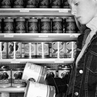 Photo of a girl looking at the labels of canned goods.