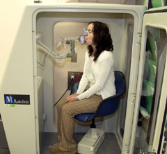 Woman sitting in pulmonary function booth.